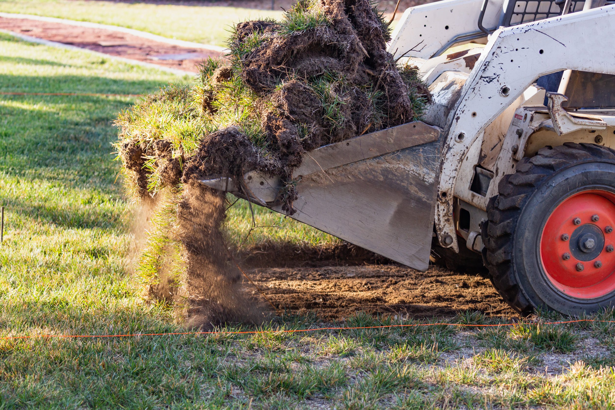 Small Bulldozer Removing Grass From Yard Preparing For Pool Installation Small Bulldozer Removing Grass From Yard Preparing For Pool Installation